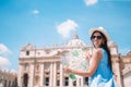 Happy young woman with city map in Vatican city and St. Peter`s Basilica church, Rome, Italy. Royalty Free Stock Photo