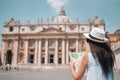 Happy young woman with city map in Vatican city and St. Peter`s Basilica church Royalty Free Stock Photo