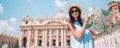 Happy young woman with city map in Vatican city and St. Peter`s Basilica church Royalty Free Stock Photo