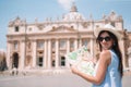 Happy young woman with city map in Vatican city and St. Peter`s Basilica church Royalty Free Stock Photo
