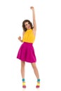 Happy Young Woman In Colorful High Heels And Pink Mini Skirt Is Standing With Fist Raised And Talking
