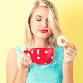 Happy young woman with cookie and coffee Royalty Free Stock Photo