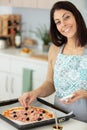 happy young woman cooking pizza at home in oven Royalty Free Stock Photo