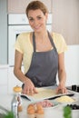 Happy young woman cooking pizza at home Royalty Free Stock Photo