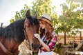 Happy young woman cowgirl standing with her horse on ranch Royalty Free Stock Photo