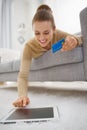 Happy young woman with credit card using tablet pc Royalty Free Stock Photo