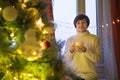 Happy young woman with cup of coffee or tea at home over christmas tree Royalty Free Stock Photo