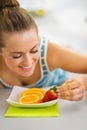 Happy young woman decorating plate with fruits Royalty Free Stock Photo