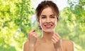 Happy young woman with dental floss cleaning teeth