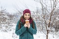 Happy young woman with disposable cup of coffee or tea wearing warm clothing. Beautiful girl holding disposable cup,standing Royalty Free Stock Photo