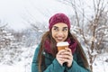 Happy young woman with disposable cup of coffee or tea wearing warm clothing. Beautiful girl holding disposable cup,standing Royalty Free Stock Photo