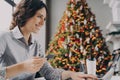 Happy young woman doing online shopping on laptop computer at home during Winter holidays sales