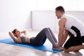 Young Woman Doing Sit Ups With Help Of Trainer Royalty Free Stock Photo