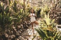 Happy young woman standing in yoga pose on the wooden bridge in jungle