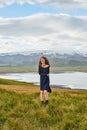 Happy young woman in dress enjoying beautiful nature in Iceland, standing against impressive mountains and cloudy sky Royalty Free Stock Photo