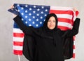 Happy young woman dressed in traditional islamic clothes with american flag Royalty Free Stock Photo