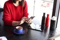 Happy young woman drinking cappuccino, latte, macchiato, tea, using tablet computer and talking on the phone in a coffee shop / ba Royalty Free Stock Photo