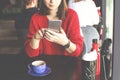 Happy young woman drinking cappuccino, latte, macchiato, tea, using tablet computer and talking on the phone in a coffee shop / ba Royalty Free Stock Photo