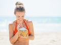 Happy young woman drinking coconut milk on beach Royalty Free Stock Photo