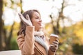 Happy young woman drinking coffee in autumn park Royalty Free Stock Photo