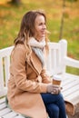 Happy young woman drinking coffee in autumn park Royalty Free Stock Photo