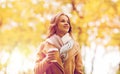 Happy young woman drinking coffee in autumn park Royalty Free Stock Photo