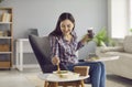 Happy young woman drinking coffee and eating salad from takeaway meal delivery service Royalty Free Stock Photo