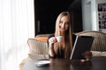 Happy young woman drinking coffee tea and using tablet Royalty Free Stock Photo
