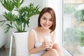 Happy young woman drinking milk by the kitchen at home. Royalty Free Stock Photo