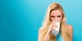 Happy young woman drinking milk on a solid background Royalty Free Stock Photo