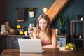 Happy young woman drinking white wine while video chatting Royalty Free Stock Photo