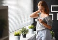 Happy young woman drinks coffee at window in morning Royalty Free Stock Photo