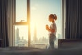 Happy young woman drinks coffee in morning at window Royalty Free Stock Photo