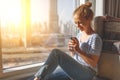 Happy young woman drinks coffee in morning at window Royalty Free Stock Photo