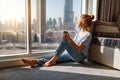 Happy young woman drinks coffee in morning at window Royalty Free Stock Photo