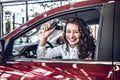 Happy young woman driver holding auto keys in her new modern luxury car Royalty Free Stock Photo