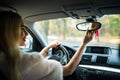 Happy young woman driver looking adjusting rear view car mirror, making sure line is free visibility is good before making turn. S Royalty Free Stock Photo