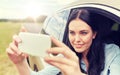 Happy young woman driving in car with smartphone Royalty Free Stock Photo