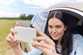 Happy young woman driving in car with smartphone Royalty Free Stock Photo