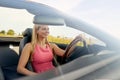 Happy young woman driving convertible car Royalty Free Stock Photo