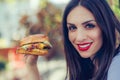 Happy young woman eat tasty fast food burger