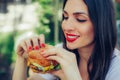 Happy young woman eat tasty fast food burger Royalty Free Stock Photo