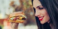 Happy young woman eat tasty fast food burger