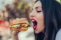 Happy young woman eat tasty fast food burger Royalty Free Stock Photo