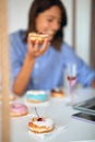 A happy young woman is eating delicious donuts in a pastry shop. Pastry shop, dessert, sweet Royalty Free Stock Photo