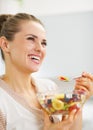 Happy young woman eating fresh fruits salad Royalty Free Stock Photo