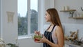 Happy young woman eating fresh raw vegetable salad posing at kitchen having positive emotion Royalty Free Stock Photo