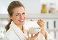 Happy young woman eating muesli in kitchen Royalty Free Stock Photo