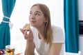 Happy young woman eating a piece of hot pizza at home and enjoying a delicious meal Royalty Free Stock Photo