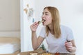 Happy young woman eating a piece of hot pizza at home and enjoying a delicious meal Royalty Free Stock Photo